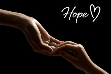 Image of Concept of hope. Woman with child on black background, closeup of hands