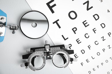Different ophthalmologist tools on white table, flat lay