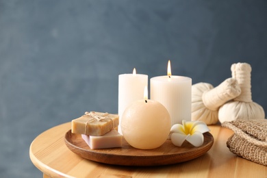 Photo of Spa composition with candles and cosmetic products on wooden table, space for text