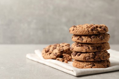 Photo of Delicious chocolate chip cookies on light grey table. Space for text