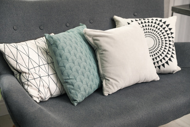 Stylish decorative pillows on grey couch, closeup