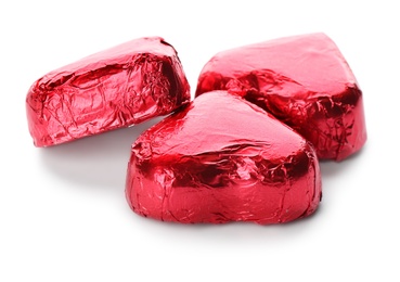 Heart shaped chocolate candies in red foil on white background