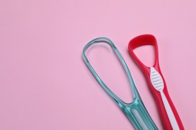 Tongue cleaners on pink background, flat lay. Space for text