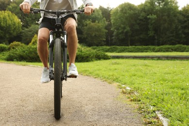 Photo of Man riding bicycle on road outdoors, closeup. Space for text