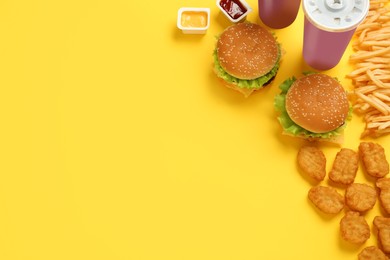Flat lay composition with delicious fast food menu on yellow background. Space for text