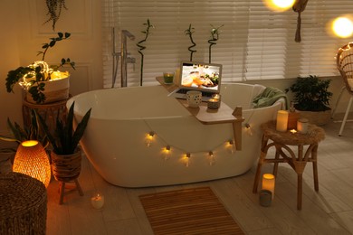 Stylish bathroom interior with green houseplants and string lights. Idea for design