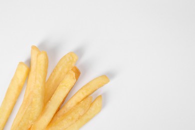 Photo of Delicious french fries on white background, flat lay. Space for text