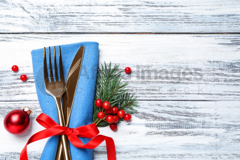 Cutlery set on wooden table, top view with space for text. Christmas celebration