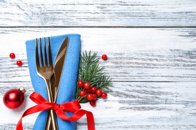 Photo of Cutlery set on wooden table, top view with space for text. Christmas celebration