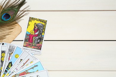 Flat lay composition with Queen of Pentacles and other tarot cards on white wooden table. Space for text