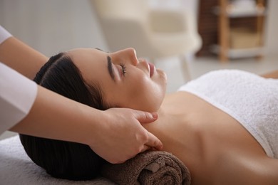 Photo of Young woman enjoying professional massage in spa salon, closeup