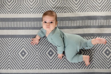 Cute baby crawling on floor, top view