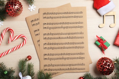 Flat lay composition with Christmas music sheets on wooden background