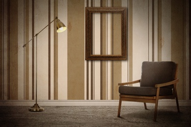 Armchair, floor lamp near wall with wooden frame and patterned wallpaper. Stylish room interior