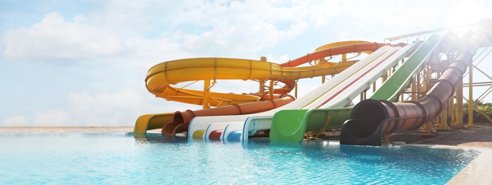 Beautiful view of water park with colorful slides and swimming pool on sunny day. Banner design