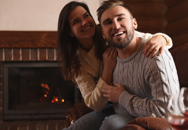 Lovely couple resting near fireplace at home. Winter vacation