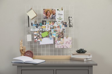 Chest of drawers with vision board and decor elements near grey wall indoors