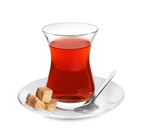 Glass of traditional Turkish tea with sugar cubes and spoon isolated on white