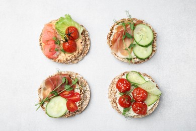 Photo of Set of crunchy buckwheat cakes with different ingredients on white background, flat lay