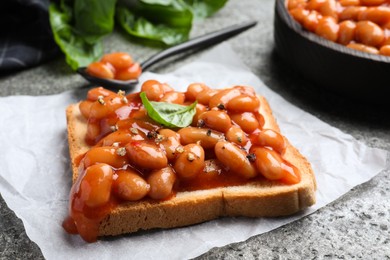 Toast with delicious canned beans on grey table