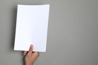 Photo of Man holding sheets of paper on grey background, closeup. Mockup for design