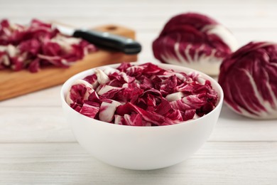 Photo of Cut radicchio in bowl on white wooden table
