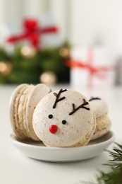 Photo of Tasty reindeer Christmas macarons on white table, closeup