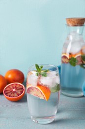 Delicious refreshing drink with sicilian orange and mint on grey wooden table