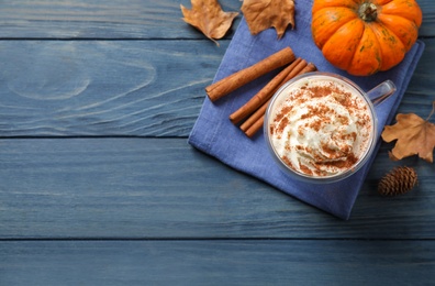 Delicious pumpkin latte on blue wooden table, flat lay. Space for text
