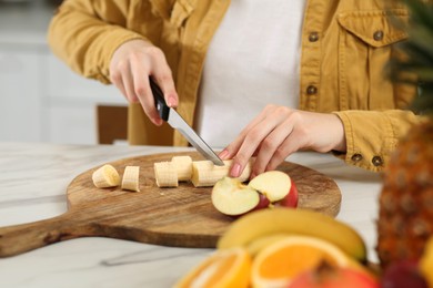Photo of Woman preparing ingredients for tasty smoothie at white marble table in kitchen, closeup