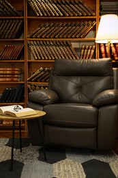 Cozy home library interior with leather armchair and collection of vintage books on shelves