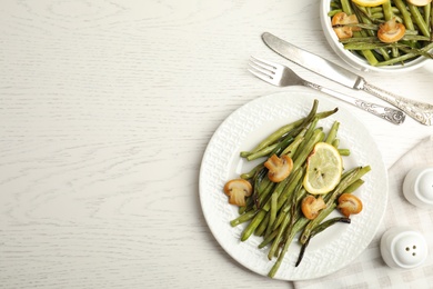 Delicious baked green beans served on white table. Space for text