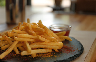 Delicious hot french fries with red sauce served on table