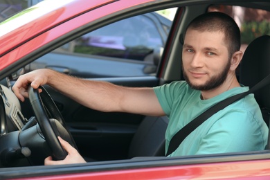 Man with fastened safety belt on driver's seat in car
