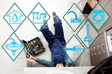 Sanitary engineering service. Professional plumber repairing kitchen sink, top view