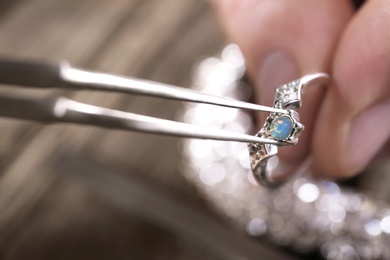 Male jeweler examining ring in workshop, closeup view