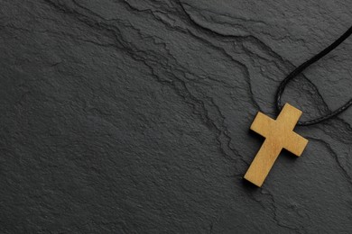Christian cross on black table, top view. Space for text