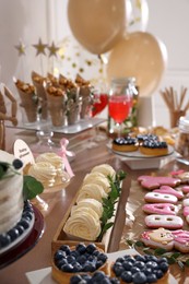 Baby shower party. Different delicious treats on wooden table indoors