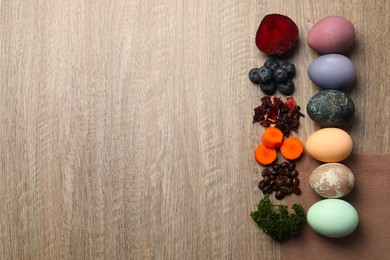 Photo of Naturally painted Easter eggs and space for text on wooden table, flat lay. Beetroot, blueberries, hibiscus, carrot, coffee beans, parley used for coloring