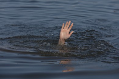 Photo of Drowning woman reaching for help in sea, closeup