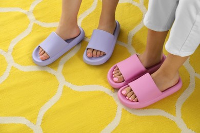 Photo of Women in pink and violet slippers indoors, closeup. Space for text