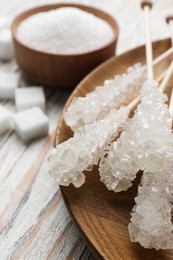 Different types of sugar on white wooden table, closeup