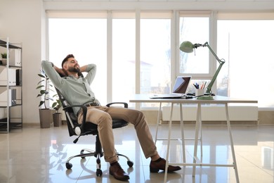 Businessman relaxing in office chair at workplace
