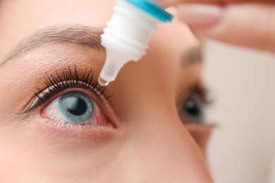 Closeup view of woman using eye drops