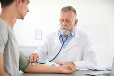 Doctor measuring patient's blood pressure in hospital