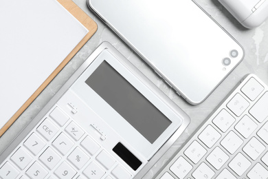 Calculator, smartphone and keyboard on grey table, flat lay. Tax accounting