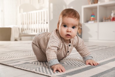 Cute baby crawling on floor at home