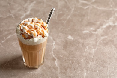 Glass with delicious caramel frappe on grey background