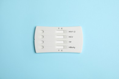 One disposable express test for hepatitis on light blue background, top view