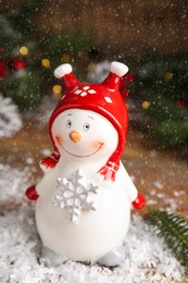 Photo of Cute snowman figure on table. Christmas decor